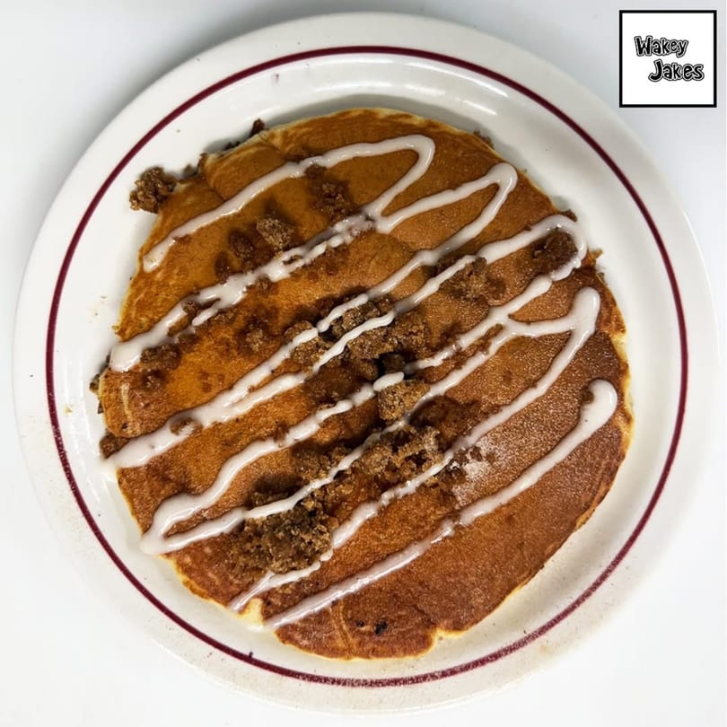 A Wakey Jake's cinnamon roll pancake, drizzled with white icing and topped with brown sugar crumble.