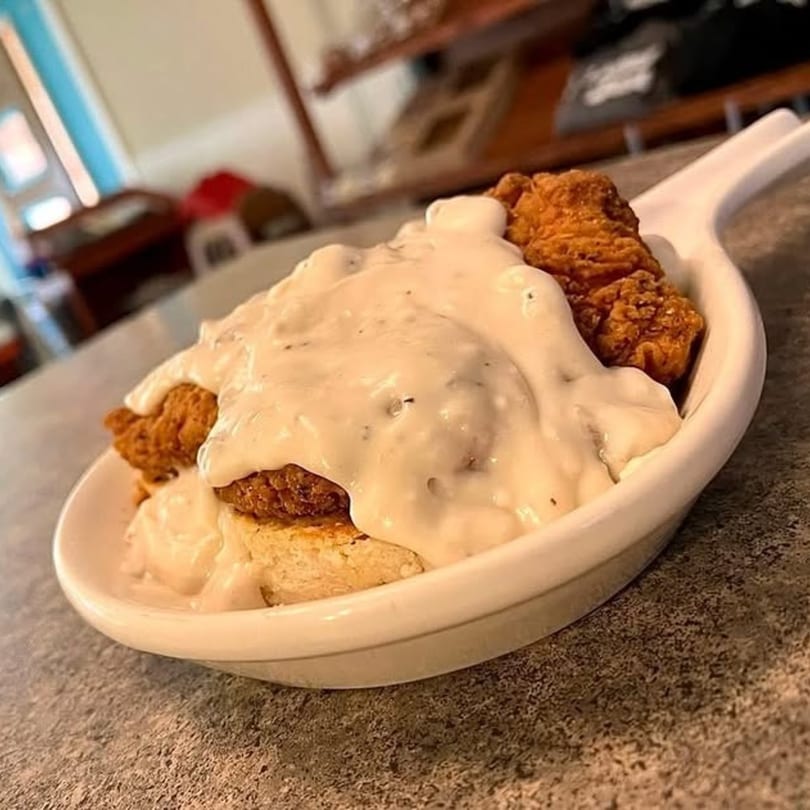 Wakey Jake's diner-style biscuits and gravy with fried chicken in a white dish.
