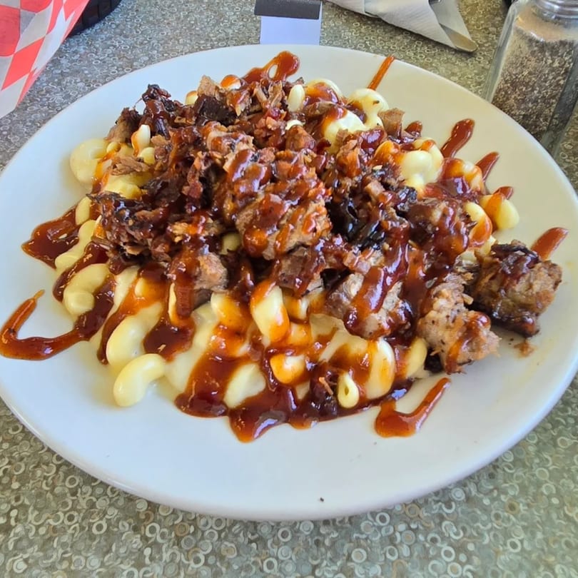 Wakey Jake's diner mac and cheese topped with barbecue pulled pork and drizzled with sauce.